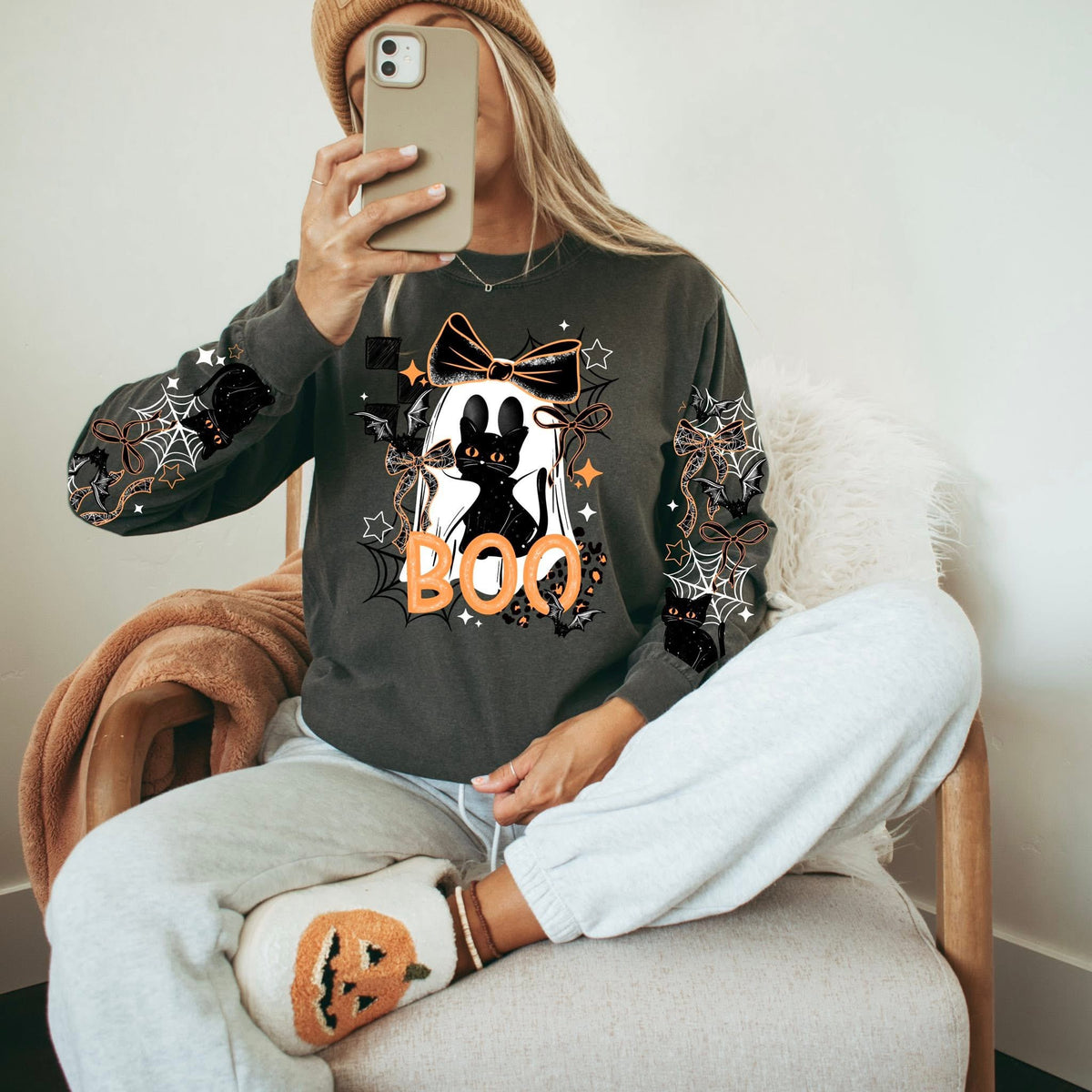 Ghostie holding her Black Cat sweatshirt with sleeve designs